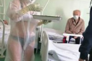 ロシア看護婦がブラジャーとパンティーの上に透明の防護服でコロナ治療